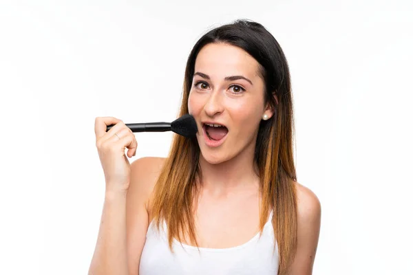 Jonge vrouw het houden van een heleboel make-up borstel over geïsoleerde witte achtergrond — Stockfoto