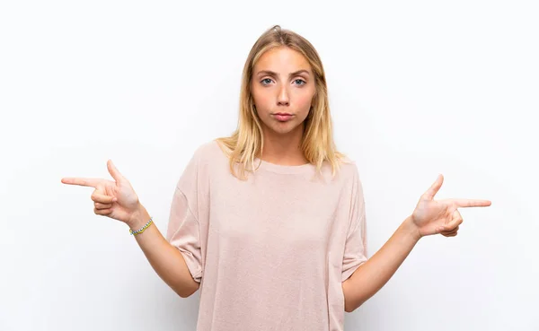 Blonde Jonge Vrouw Geïsoleerde Witte Achtergrond Wijzend Naar Lateralen Die — Stockfoto