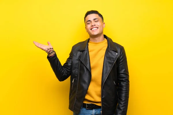 Joven Sobre Fondo Amarillo Aislado Sosteniendo Espacio Copia Imaginario Palma — Foto de Stock