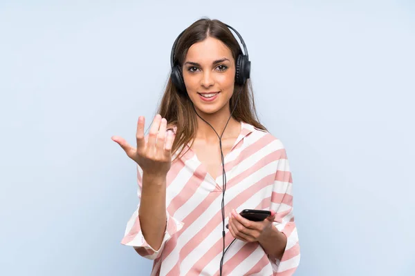 Jeune Femme Écoutant Musique Avec Mobile Sur Mur Bleu Isolé — Photo