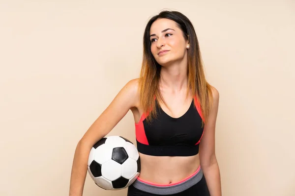 Bir futbol topu tutan izole arka plan üzerinde genç spor kadın — Stok fotoğraf