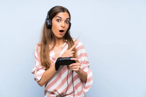 Young Woman Playing Video Game Controller Isolated Blue Wall Surprised — Stock Photo, Image