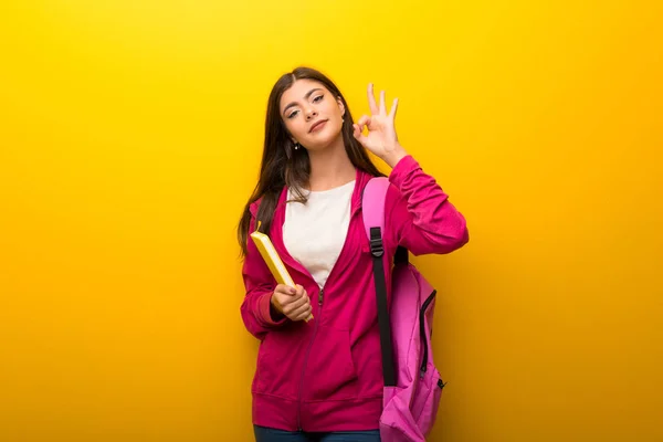 Nastolatek Student Dziewczyna Żywe Żółte Tło Pokazując Znak Palcami — Zdjęcie stockowe