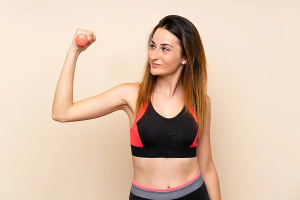 Mujer deportiva joven sobre fondo aislado haciendo levantamiento de pesas —  Fotos de Stock