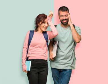 Sırt çantaları ve kitapları ile iki öğrenci sadece bir şey fark etti ve renkli duvarda çözüm niyetinde