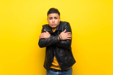 Izole sarı arka plan donma üzerinde genç adam