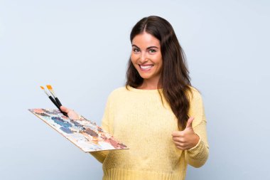 İyi bir şey oldu çünkü başparmak ile izole mavi arka plan üzerinde genç sanatçı kadın