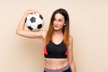 Bir futbol topu tutan izole arka plan üzerinde genç spor kadın