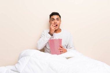 Patlamış mısırile yatakta genç adam