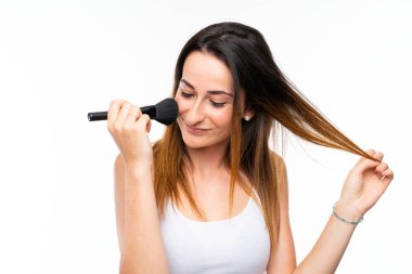 Genç kadın izole beyaz arka plan üzerinde makyaj fırçası bir sürü tutan