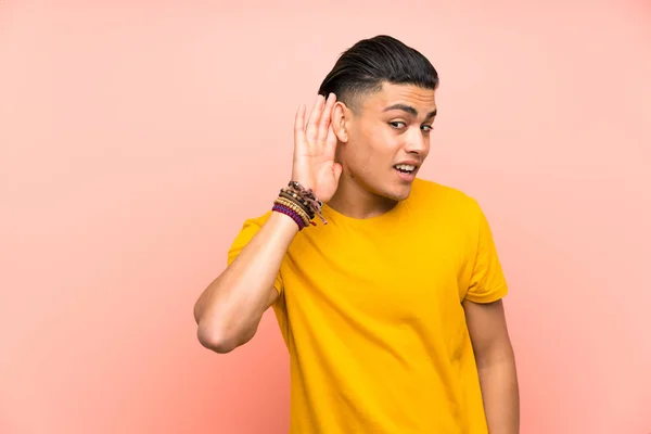 Jonge Man Met Geel Shirt Geïsoleerde Roze Muur Luisteren Iets — Stockfoto