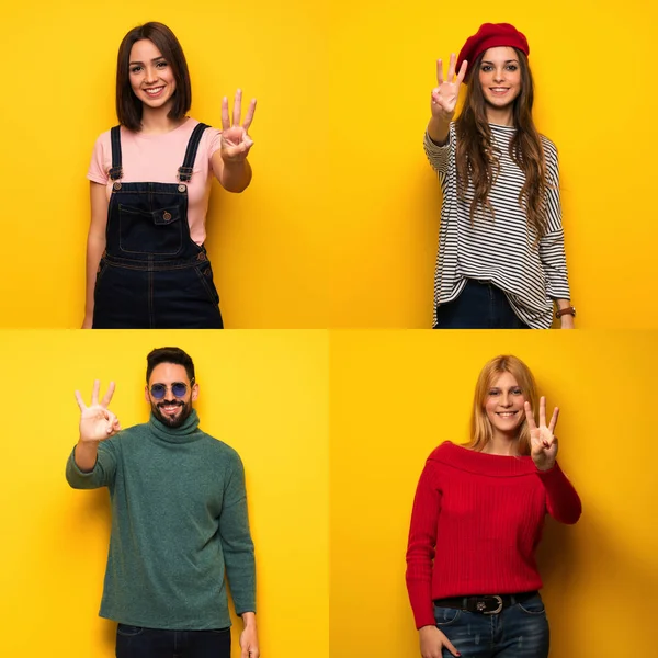 Bir grup insan mutlu ve parmaklarıyla üçe kadar sayıyor.