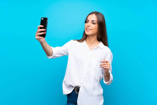 Mujer Joven Sobre Fondo Azul Aislado Haciendo Una Selfie —  Fotos de Stock
