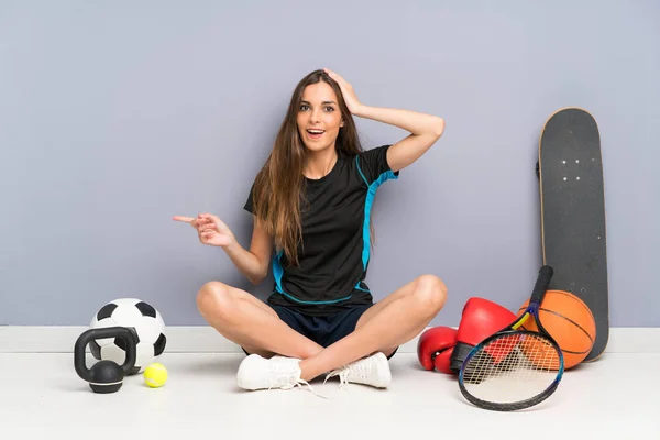 Jovem Mulher Esporte Sentado Chão Surpreso Apontando Dedo Para Lado — Fotografia de Stock