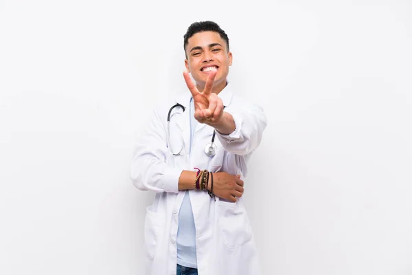 Mladý Lékař Izolované Bílé Zdi Usmívá Zobrazuje Vítězné Znamení — Stock fotografie
