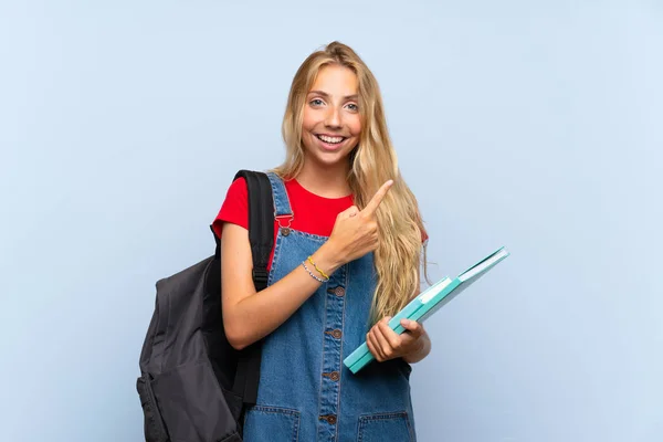 Jovem Loira Estudante Mulher Sobre Isolado Azul Parede Apontando Dedo — Fotografia de Stock
