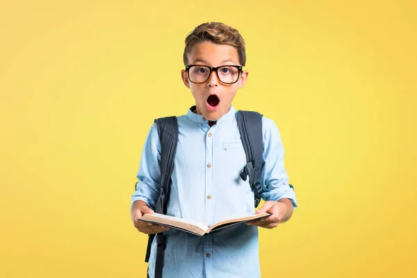 Dziecko Student Plecaka Okulary Trzymając Książkę Żółtym Tle — Zdjęcie stockowe