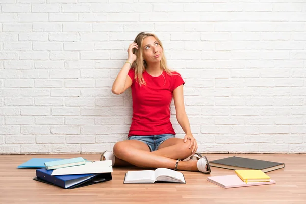 Joven Estudiante Rubia Con Muchos Libros Suelo Teniendo Dudas Con — Foto de Stock