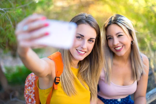 Bir parkta selfie yapma sırt çantası ile genç öğrenci kızlar