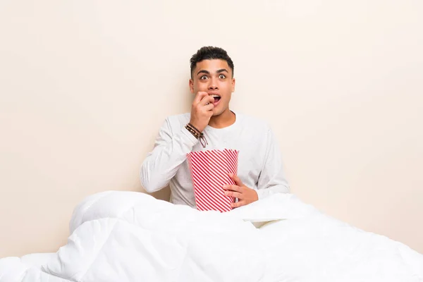 젊은 남자 에 침대 와 팝콘 — 스톡 사진