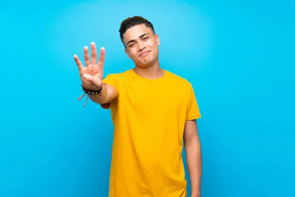 Mladý Muž Žlutou Košilí Přes Izolované Modré Pozadí Šťastný Počítám — Stock fotografie