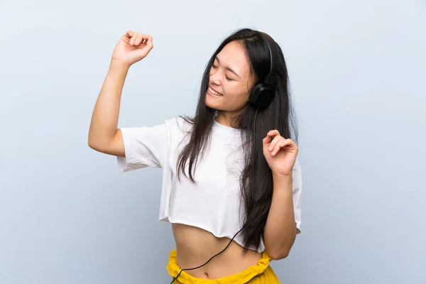 Tiener Aziatische Meisje Luisteren Muziek Geïsoleerde Blauwe Muur — Stockfoto