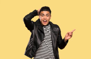 Genç adam şaşırttı ve izole arka plan üzerinde yan parmak işaret