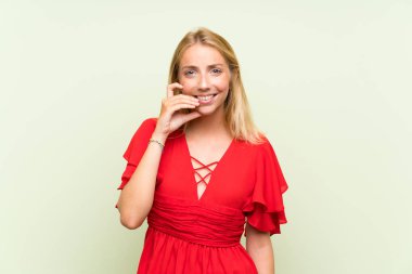 Izole yeşil arka plan sinirli ve korkmuş üzerinde Sarışın genç kadın