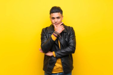 Izole sarı arka plan düşünme üzerinde genç adam