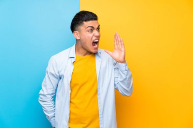 Ağzı tamamen açık bağırarak izole renkli arka plan üzerinde genç adam