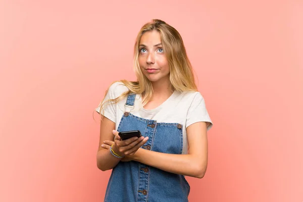 Mujer Joven Rubia Con Teléfono Móvil Sobre Una Pared Rosa —  Fotos de Stock