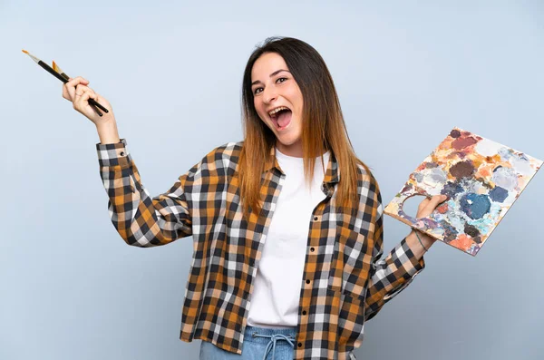 Jovem Pintor Mulher Sobre Fundo Azul Isolado — Fotografia de Stock