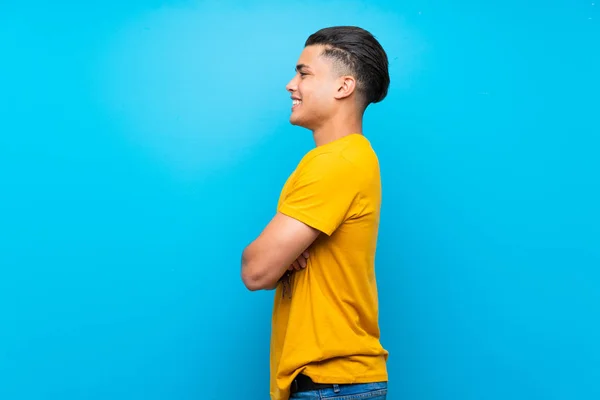 Jovem Com Camisa Amarela Sobre Fundo Azul Isolado Posição Lateral — Fotografia de Stock