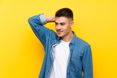 Genç yakışıklı adam, izole edilmiş sarı arka plan gülüyor.