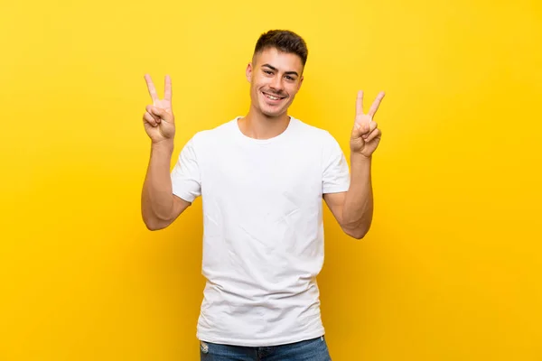 Izole Sarı Arka Plan Üzerinde Genç Yakışıklı Adam Iki Eliyle — Stok fotoğraf