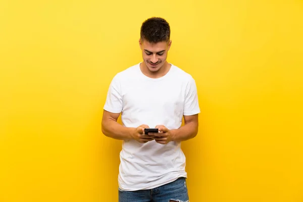 Junger Gutaussehender Mann Über Isoliertem Gelben Hintergrund Sendet Eine Nachricht — Stockfoto