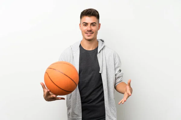 Спортсмен над ізольованою білою стіною з м'ячем баскетболу — стокове фото