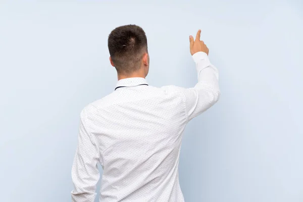 Hombre Negocios Guapo Sobre Fondo Azul Aislado Apuntando Hacia Atrás —  Fotos de Stock