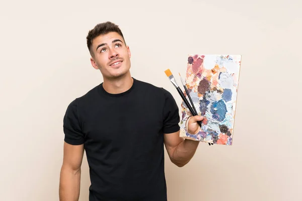 Młody Artysta Człowiek Białym Tle Patrząc Górę Podczas Uśmiechnięty — Zdjęcie stockowe