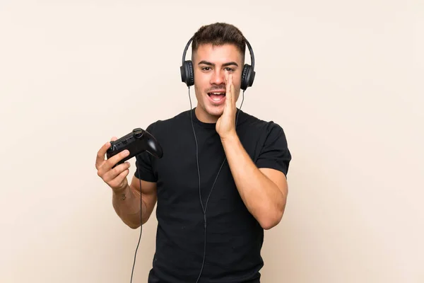 Νέος Όμορφος Άντρας Παίζει Ένα Χειριστήριο Βιντεοπαιχνιδιών Απομονωμένο Φόντο Φωνάζοντας — Φωτογραφία Αρχείου