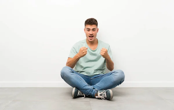 Jovem Bonitão Sentado Chão Comemorando Uma Vitória — Fotografia de Stock