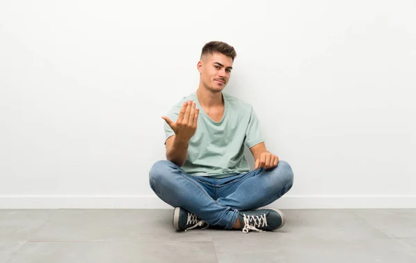 Junger Schöner Mann Sitzt Auf Dem Fußboden Und Lädt Zum — Stockfoto