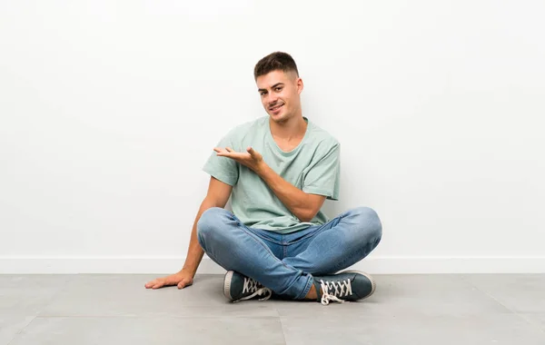 Mladý Pohledný Muž Sedící Podlaze Natahuje Ruce Stranu Aby Mohl — Stock fotografie