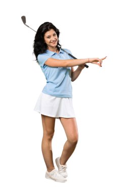 İzole beyaz arka plan üzerinde bir ürün sunmak için yan işaret Genç bir golfçü kadın tam uzunlukta bir çekim
