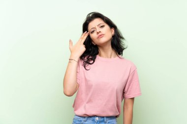 İntihar jesti yapma sorunları ile izole yeşil arka plan üzerinde genç kadın