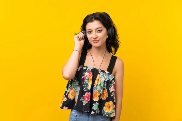 Mujer Joven Sobre Fondo Amarillo Aislado Escuchando Música Con Auriculares —  Fotos de Stock