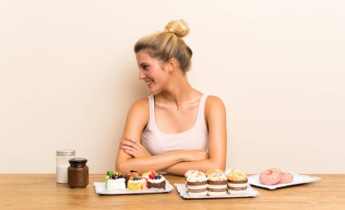 Yan bakarak bir masada farklı mini kek çok genç kadın