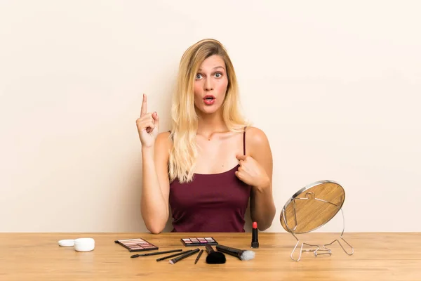 Mujer Rubia Joven Con Cosmética Una Mesa Con Expresión Facial — Foto de Stock