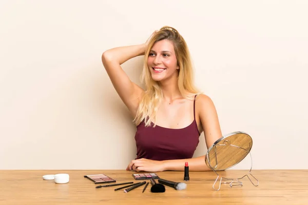 Junge Blonde Frau Mit Kosmetik Auf Einem Tisch Lacht — Stockfoto
