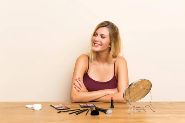 Junge Blonde Frau Mit Kosmetik Auf Einem Tisch Stehend Und — Stockfoto